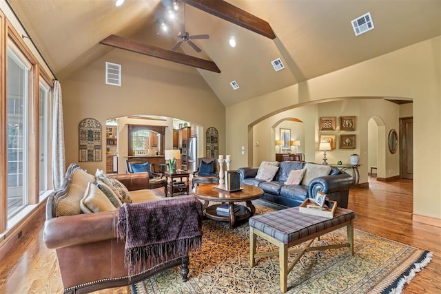 3920 Creek Bank Dr, Edmond, OK 73003 - living room with arched walkways, ceiling fan, high vaulted ceiling, beam ceiling, and wood finished floors