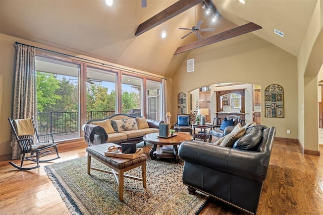 3920 Creek Bank Dr, Edmond, OK 73003 - living area featuring beamed ceiling, high vaulted ceiling, arched walkways, wood finished floors, and a ceiling fan