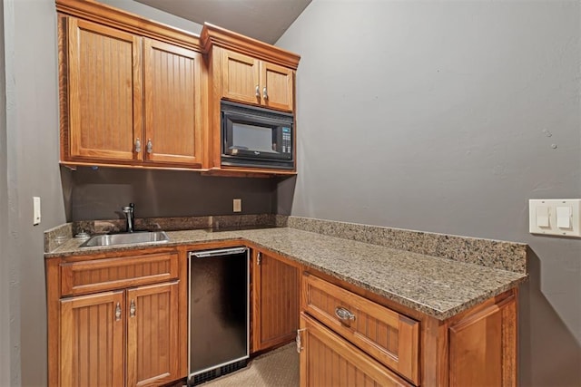 3920 Creek Bank Dr, Edmond, OK 73003 - kitchen featuring black microwave, light stone countertops, and brown cabinets