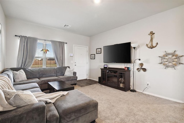 living room featuring carpet floors, baseboards, and visible vents