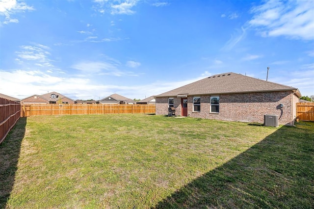 view of yard with central air condition unit and a fenced backyard