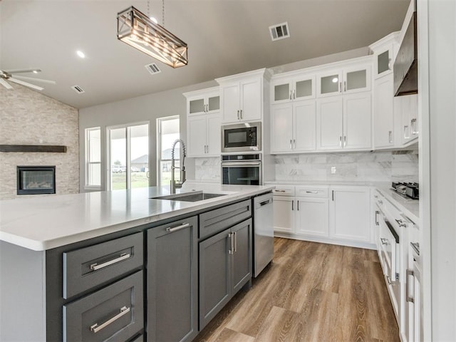 kitchen with a sink, appliances with stainless steel finishes, gray cabinets, and visible vents