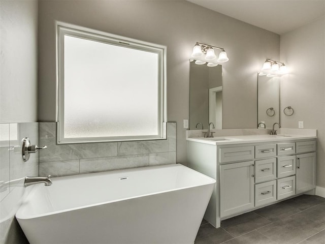 full bathroom featuring double vanity, a sink, tile patterned flooring, and a soaking tub