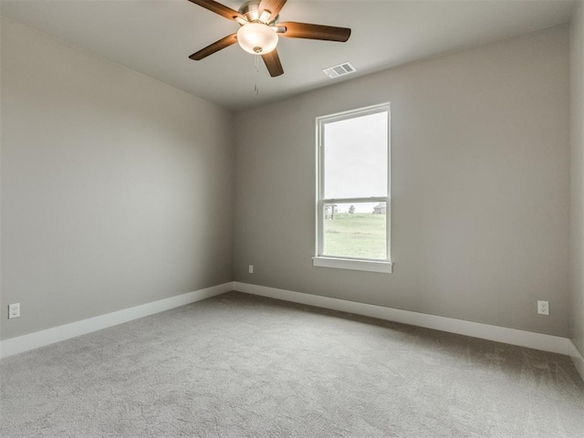 spare room with carpet floors, baseboards, ceiling fan, and visible vents