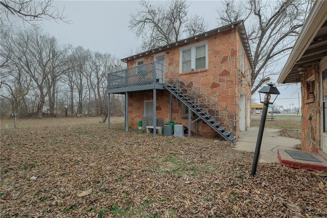 1319 S Division St, Guthrie, OK 73044 - rear view of house featuring stairs, a deck, and stone siding