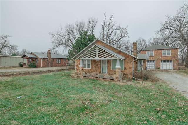 1319 S Division St, Guthrie, OK 73044 - view of front facade featuring driveway, stone siding, a chimney, a front yard, and an attached garage