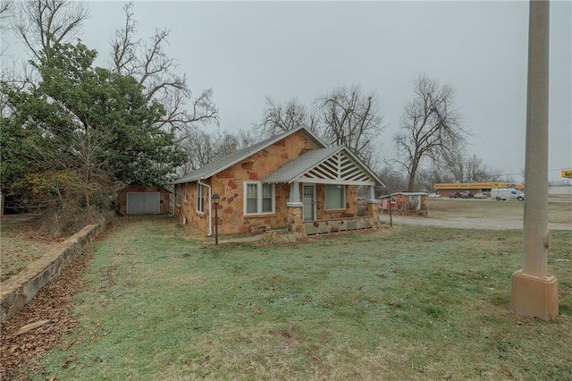 1319 S Division St, Guthrie, OK 73044 - view of side of property with stone siding, a lawn, and a storage shed
