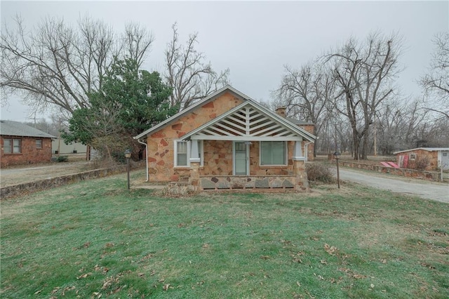 1319 S Division St, Guthrie, OK 73044 - bungalow-style house featuring stone siding, a front lawn, and a chimney