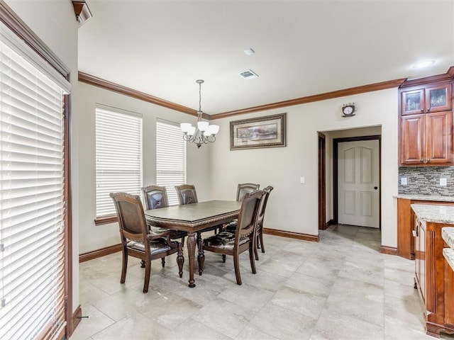dining area with a notable chandelier, visible vents, baseboards, and crown molding