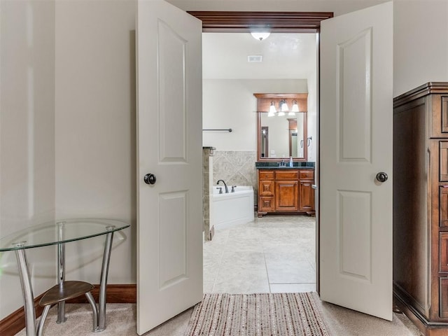 bathroom featuring tile patterned floors, vanity, and a bath