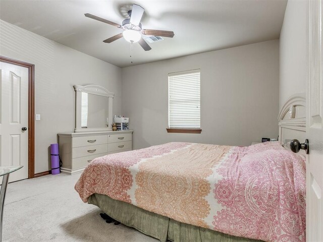 bedroom featuring light carpet, visible vents, multiple windows, and ceiling fan