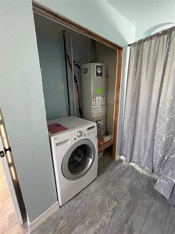 8100 NE 23rd St, Midwest City, OK 73141 - clothes washing area featuring laundry area, washer / dryer, and water heater