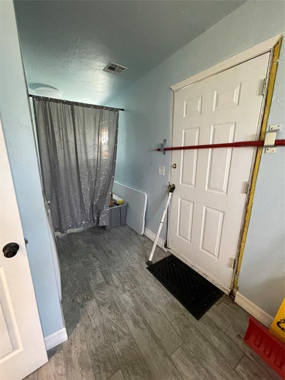 8100 NE 23rd St, Midwest City, OK 73141 - entryway featuring baseboards, wood finished floors, and visible vents