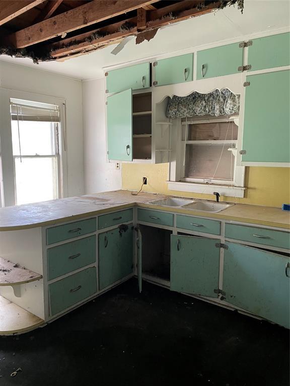 8100 NE 23rd St, Midwest City, OK 73141 - kitchen with a peninsula, open shelves, a sink, and green cabinets