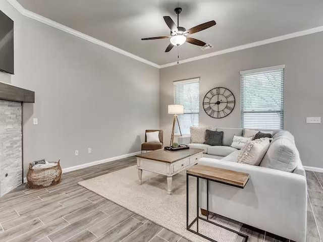 living area with ceiling fan, baseboards, ornamental molding, and wood finished floors