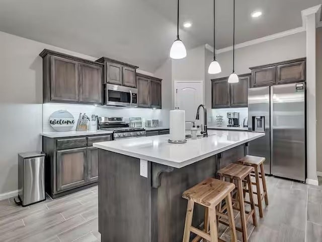 kitchen with stainless steel appliances, a kitchen breakfast bar, dark brown cabinets, light wood-type flooring, and light countertops