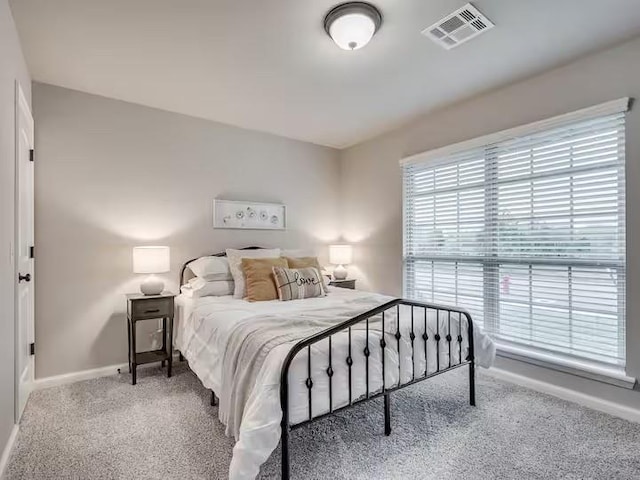carpeted bedroom featuring baseboards and visible vents