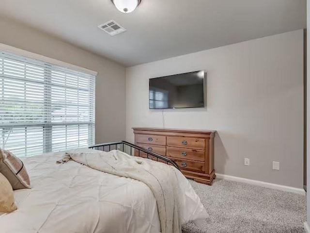carpeted bedroom with baseboards and visible vents