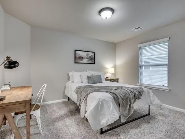 carpeted bedroom with baseboards and visible vents