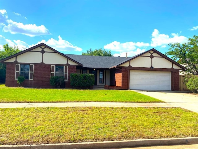 613 NE 15th St, Moore, OK 73160 - view of front of home featuring a front lawn, driveway, an attached garage, and brick siding