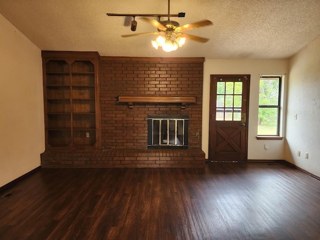 613 NE 15th St, Moore, OK 73160 - unfurnished living room featuring a textured ceiling, wood finished floors, a ceiling fan, a fireplace, and baseboards