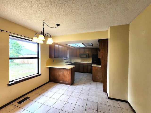 613 NE 15th St, Moore, OK 73160 - kitchen with black appliances, a peninsula, light countertops, a textured ceiling, and light tile patterned floors