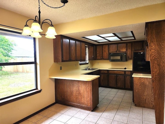 613 NE 15th St, Moore, OK 73160 - kitchen with black appliances, a sink, a textured ceiling, a peninsula, and light countertops