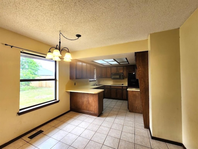 613 NE 15th St, Moore, OK 73160 - kitchen featuring black appliances, a peninsula, light countertops, a chandelier, and light tile patterned floors