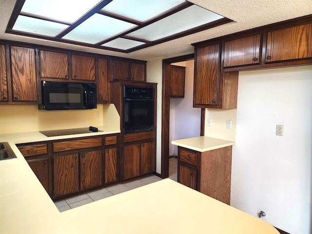 613 NE 15th St, Moore, OK 73160 - kitchen with black appliances, light countertops, and light tile patterned flooring