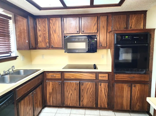 613 NE 15th St, Moore, OK 73160 - kitchen with black appliances, a sink, light countertops, and light tile patterned floors