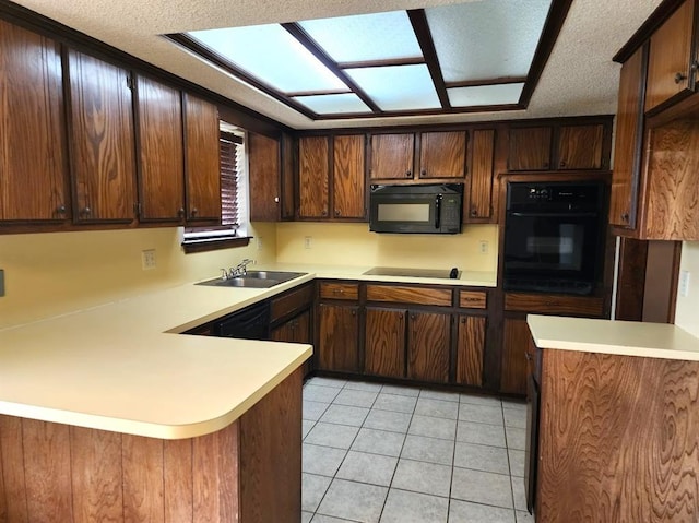 613 NE 15th St, Moore, OK 73160 - kitchen with black appliances, a sink, a peninsula, light countertops, and light tile patterned floors
