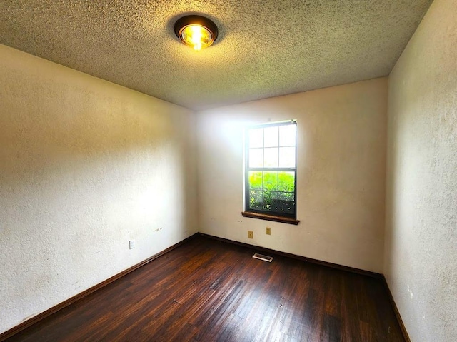 613 NE 15th St, Moore, OK 73160 - empty room with dark wood-style floors, a textured wall, baseboards, and a textured ceiling
