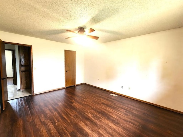 613 NE 15th St, Moore, OK 73160 - unfurnished bedroom featuring wood finished floors, baseboards, a textured ceiling, and a ceiling fan
