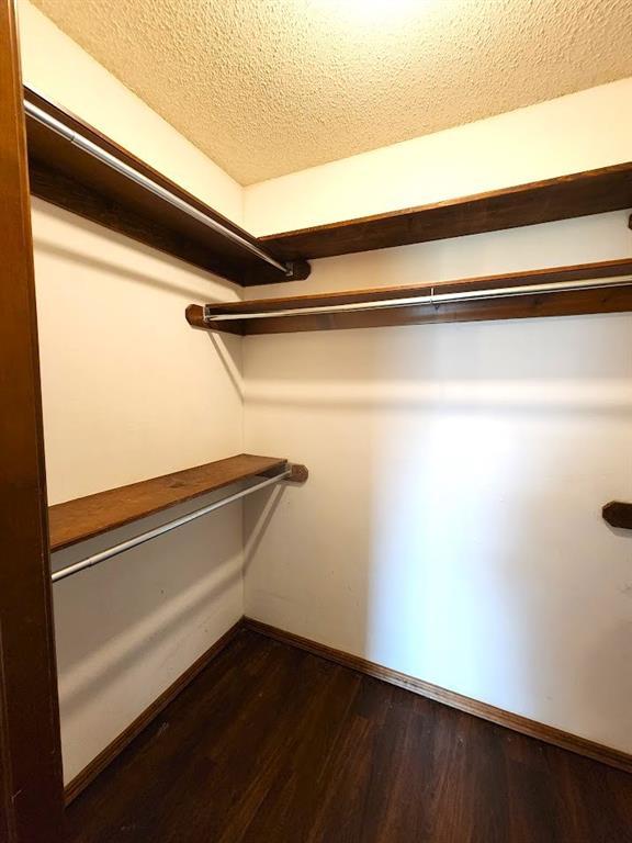 613 NE 15th St, Moore, OK 73160 - spacious closet featuring dark wood-style flooring
