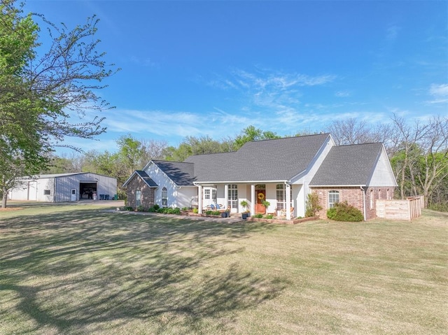 2400 Lost Lake Ln, Yukon, OK 73099 - view of front of home featuring a porch, a front yard, brick siding, a garage, and an outbuilding