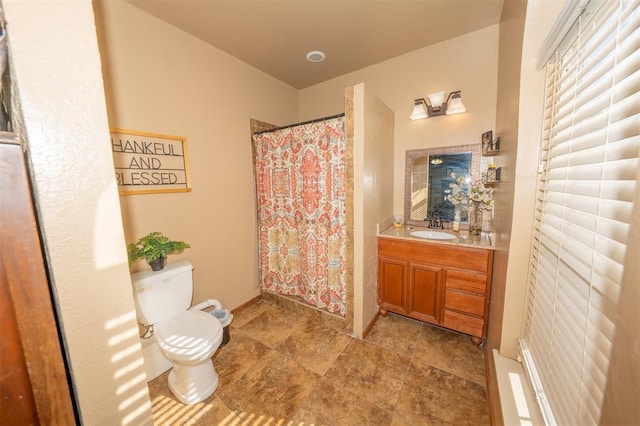 2400 Lost Lake Ln, Yukon, OK 73099 - bathroom featuring toilet, vanity, a shower with shower curtain, stone finish floors, and baseboards