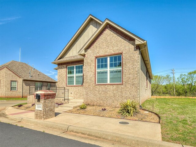 104 Rue De Montserrat, Norman, OK 73071 - view of front of house featuring brick siding, board and batten siding, and a front lawn