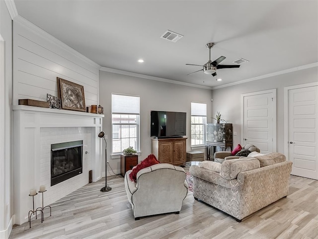 104 Rue De Montserrat, Norman, OK 73071 - living area featuring visible vents, a brick fireplace, a ceiling fan, light wood-style floors, and crown molding