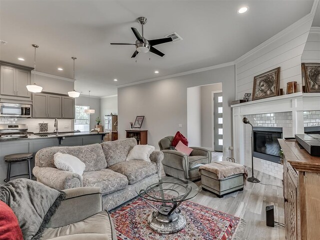 104 Rue De Montserrat, Norman, OK 73071 - living room with visible vents, ornamental molding, ceiling fan, recessed lighting, and light wood-style flooring