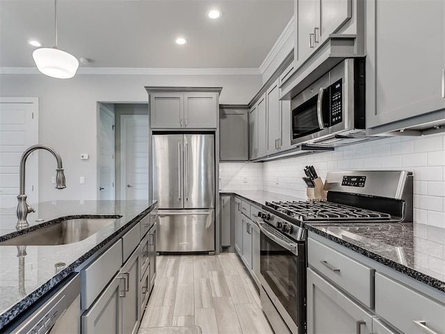 104 Rue De Montserrat, Norman, OK 73071 - kitchen with ornamental molding, dark stone countertops, gray cabinetry, appliances with stainless steel finishes, and a sink