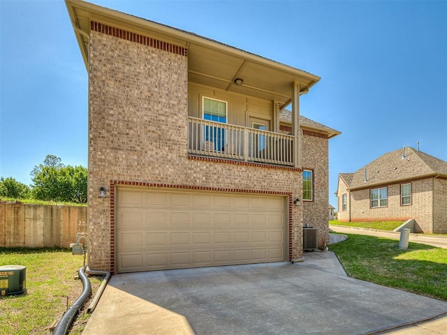 104 Rue De Montserrat, Norman, OK 73071 - view of front facade with a balcony, a garage, central air condition unit, brick siding, and concrete driveway
