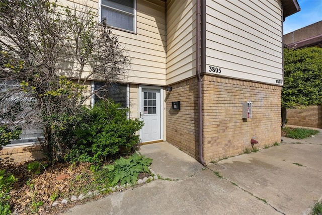 view of exterior entry with brick siding