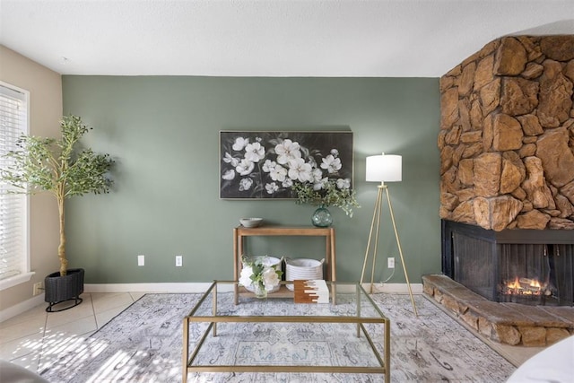 tiled home office featuring baseboards and a stone fireplace