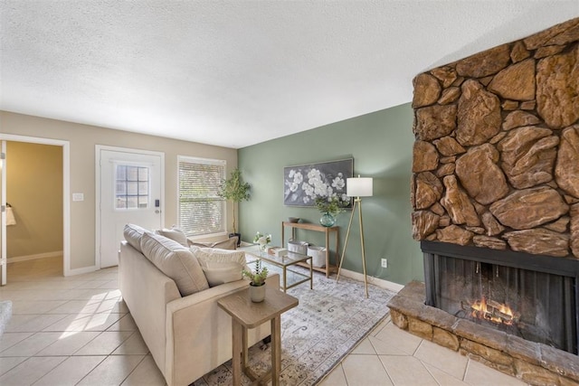 tiled living room featuring a fireplace, a textured ceiling, and baseboards
