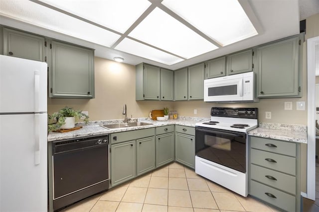 kitchen with green cabinets, a sink, white appliances, and light tile patterned floors