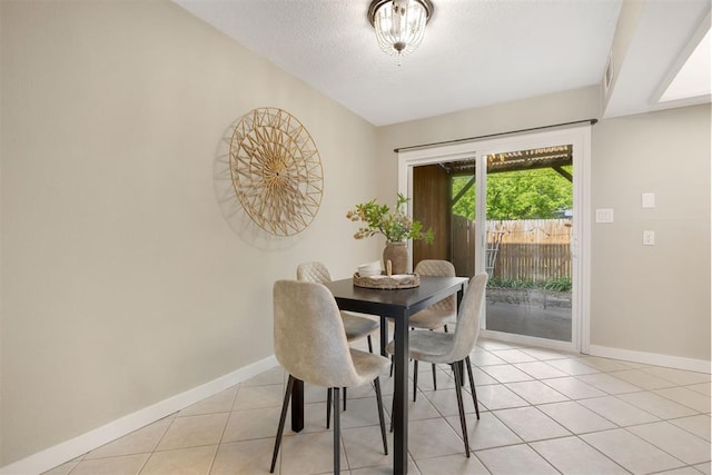 dining area featuring baseboards, a textured ceiling, visible vents, and light tile patterned floors