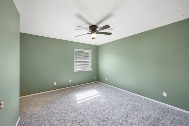 spare room with a ceiling fan, baseboards, carpet floors, and a textured ceiling