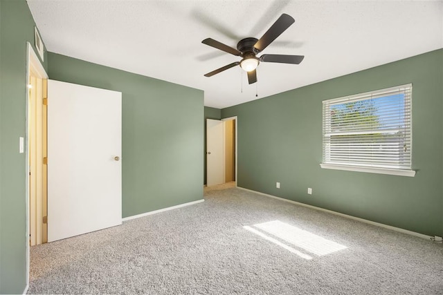 unfurnished bedroom with baseboards, a ceiling fan, carpet flooring, and visible vents