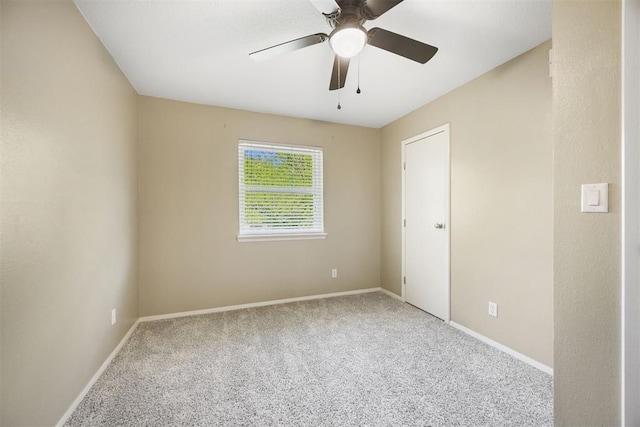 carpeted empty room with baseboards and ceiling fan