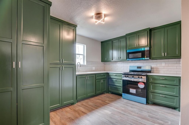 230 SE 50th St, Oklahoma City, OK 73129 - kitchen with green cabinets, stainless steel appliances, light countertops, and a textured ceiling